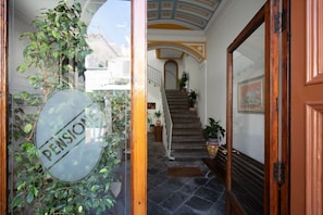 Un escalier menant à un deuxième étage, avec une porte vitrée sur le côté gauche.