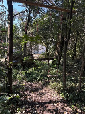 A forested area with a wooden swing set and a stone bench. - Villa pornichetaine - Beach, station & center on foot- 7 people (Pornichet)