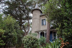 A tower-like structure with a conical roof, surrounded by dense foliage. - Villa Pornichetaine - Beach, train station, and town center within walking distance - Sleeps 7 (Pornichet)