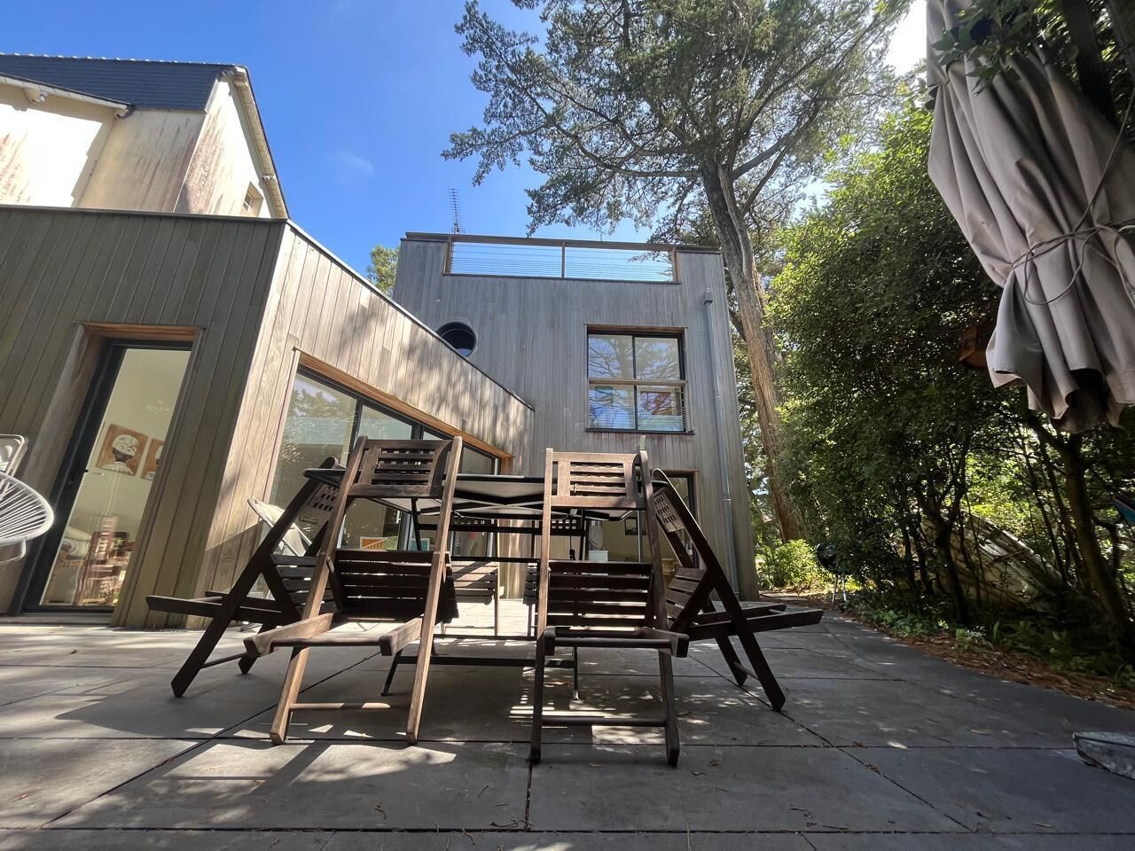 A modern building with a wooden deck and outdoor seating.