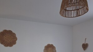 Een kamer met een witte muur, en vier geweven wanddecoraties met een rode kern.