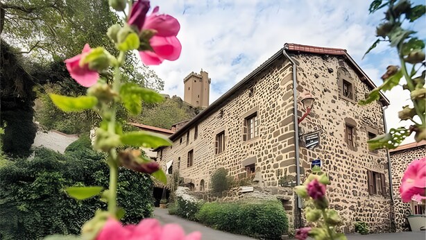 A stone building with a tower, surrounded by greenery. - Guest Room 'Chambre Rivage' with Shared Terrace & Garden, Wi-Fi (Polignac)