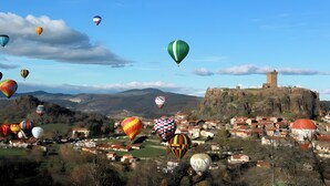 A village with a historic tower and hot air balloons in the sky. - “Romance” Guest Room with Shared Terrace, Garden, and Wi-Fi (Polignac)