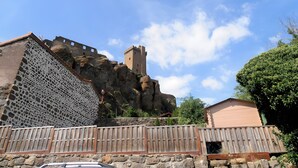 A stone building with a patterned facade and a wooden fence in the foreground. - Guest Room “Chambre Rêverie” with Shared Terrace, Garden and Wi-Fi (Polignac)