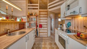 Una cucina con mobili in legno, un lavello, un fornello e un appendiabiti.