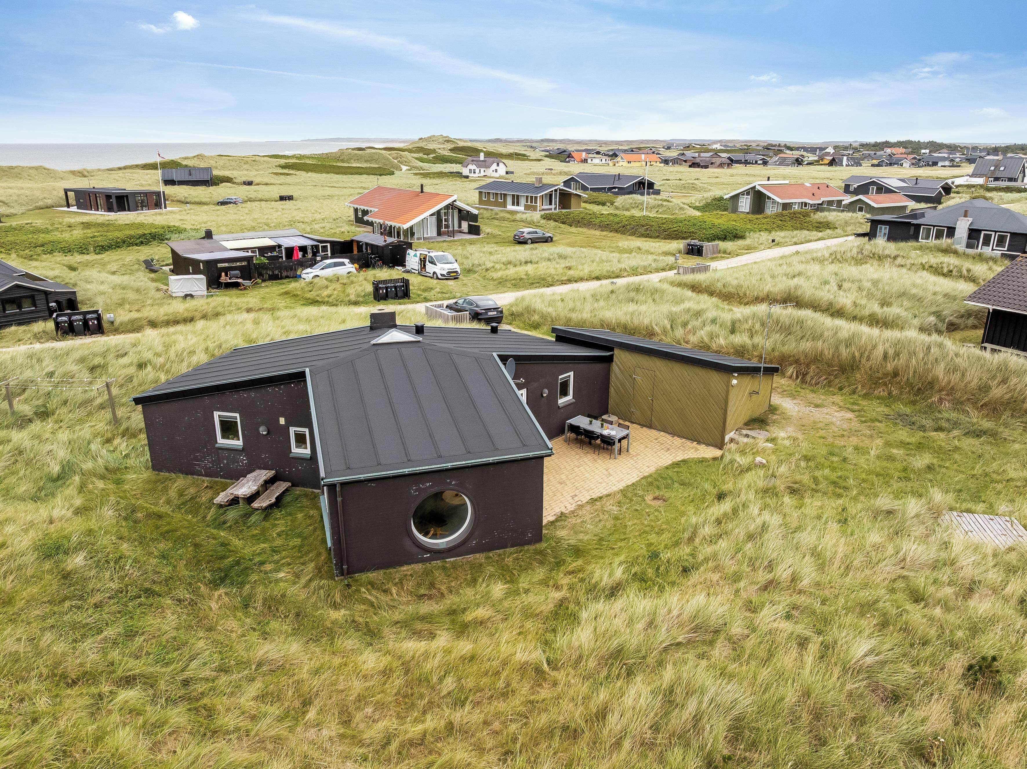 Et boligområde med huse, grønne arealer og havudsigt.