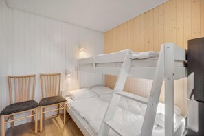 A bunk bed room with a wooden ladder, two chairs, and a wall-mounted light. - Family-friendly holiday home with large wilderness bath, close to the water. (Vestervig)