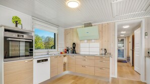 Een moderne keuken met een inbouwoven, een koffieapparaat en een groot raam.