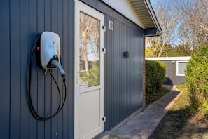A Jysk Free charging station attached to a building with a door and window. - Cozy holiday home with a wilderness bath and covered terrace. (Hurup Thy)
