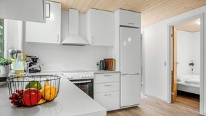A modern kitchen with white cabinets, a stainless steel sink, and a fruit bowl on the counter. - Cozy holiday home with a wilderness bath and covered terrace. (Hurup Thy)