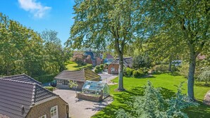 Een woonwijk met een bakstenen huis, een tuinhuis en een verzorgd gazon.