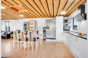 Eine moderne Küche mit integrierten Geräten, ein Essbereich mit Holzkästen und ein sichtbares Fenster.
