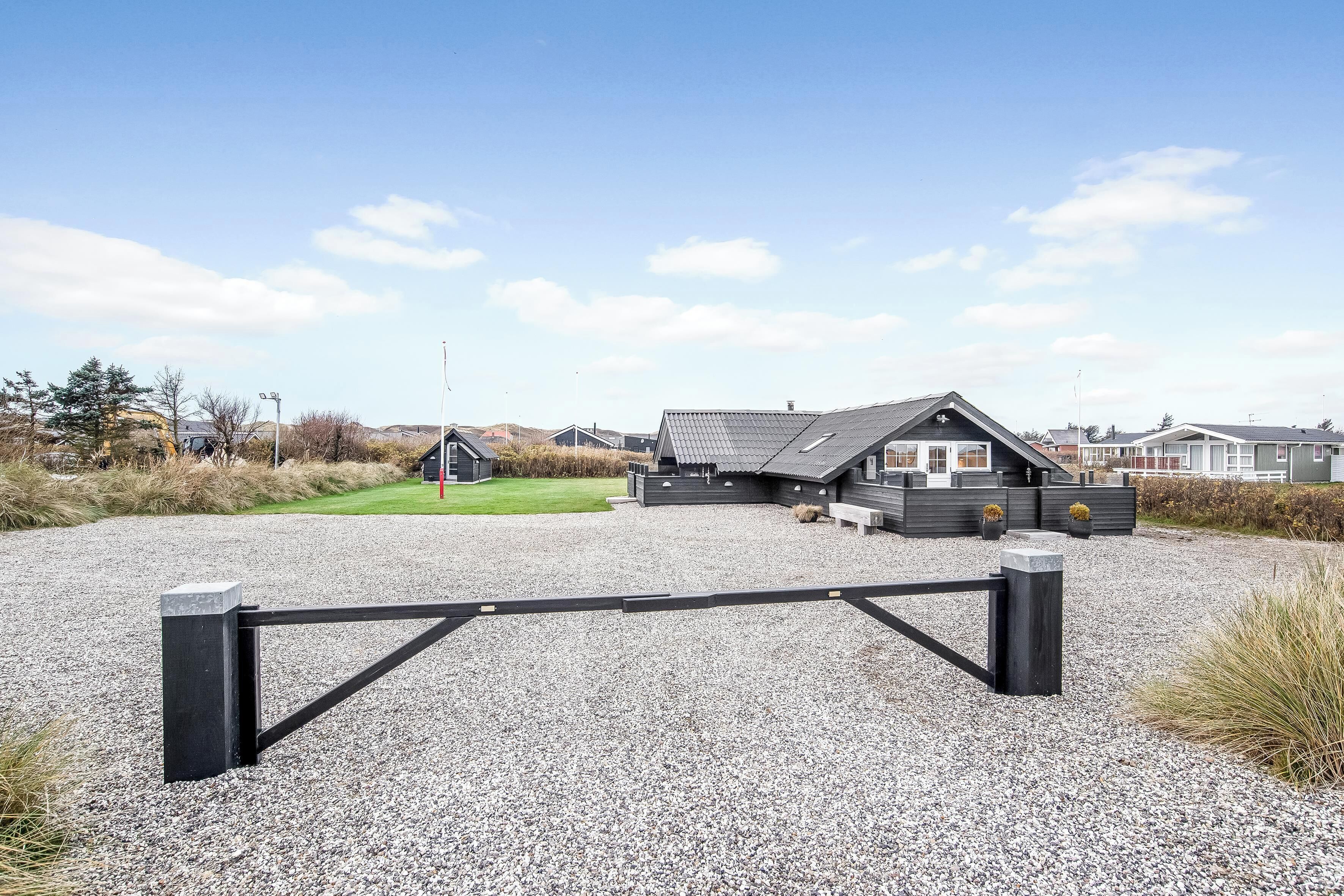 Ein modernes Gebäude mit gepflegtem Schotterweg und schwarzem Tor.