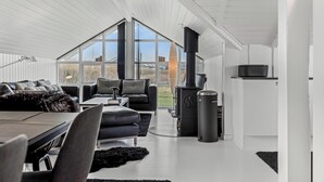 Un amplio salón con un ventanal grande, una chimenea y un comedor.
