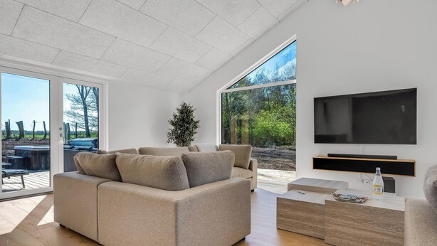 A modern living room with a sofa, TV, and a wooden coffee table.