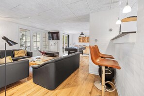 A modern living room with a pool table, black leather sofas, a coffee table, and a bar area with stools. - Large pool house in Husby with sleeping space for 18 people. (Ulfborg)