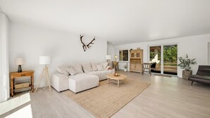 Ein modernes Wohnzimmer mit einer Couch, einem Couchtisch, einer Lampe und einem an der Wand befestigten Hirschgeweih-Dekoration.