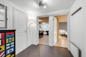 A hallway with white walls, a wooden ceiling, and a door leading to a room with a bed and a desk. - Large, well-maintained holiday home near Søndervig, with activity room,. (Ringkøbing)