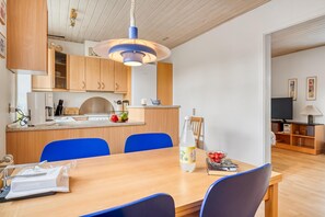 Une cuisine moderne avec des meubles en bois, un îlot central et des chaises bleues.
