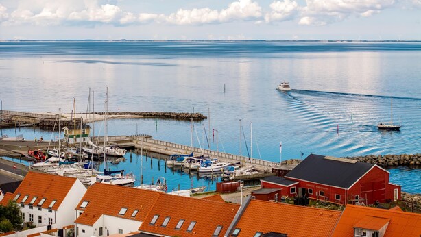 A harbor with boats, a pier, and a red building.