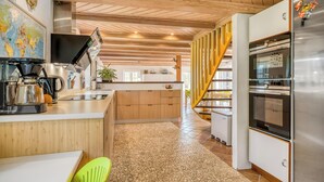 A modern kitchen with a central island, wooden ceiling, and a stainless steel refrigerator. - Lovely holiday home with wilderness bath and outdoor sauna, centrally located. (Thisted)