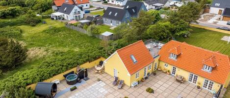 Ein Wohngebiet mit Häusern, einer Terrasse mit Gartenmöbeln und einem Schwimmbad.