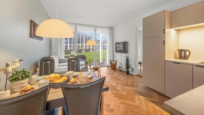 Una cucina moderna con zona pranzo, ampie finestre e vista sull'esterno.
