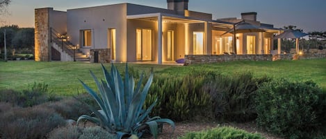 Una casa moderna con facciata in pietra, ampie finestre e un ingresso ben illuminato.