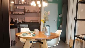 Une cuisine moderne avec une table à manger, des chaises et une machine à café.