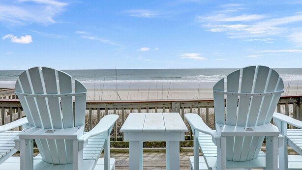 A view of the beach from a wooden deck with two Adirondack chairs and a small table. - Livin' On A Prayer - Charming 3 bedroom oceanfront cottage (North Topsail Beach)
