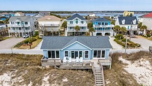 A beachfront property with multiple houses, a wooden deck, and a staircase leading to the beach. - Livin' On A Prayer - Charming 3 bedroom oceanfront cottage (North Topsail Beach)