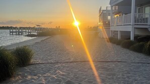 A beach with a pier, a building with a balcony, and a sunset. - Water front OASIS - Voted #1 Vacation Rental in the Jersey Shore 2024 (Seaside Heights)