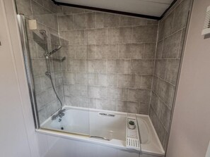 A shower with a glass door, a handheld showerhead, and a wall-mounted faucet. - Beck Lodge with Hot tub (Allerthorpe)