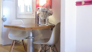 A dining area with a table, chairs, a fan, and a window with curtains. - Apartment 'Cavour' with Wi-Fi (Genova)