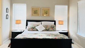 A bedroom with a bed, two bedside lamps, a ceiling fan, and two framed pictures on the wall. - Beach Access & Poolside Patio! Easter Special! (South Padre Island)
