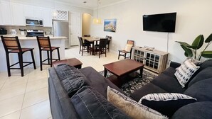 A modern living room with a sofa, coffee table, and dining area. - Beach Access & Poolside Patio! Easter Special! (South Padre Island)