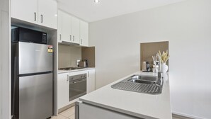 Eine moderne Küche mit Edelstahlgeräten, einem eingebauten Backofen und einer Spüle.