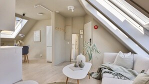 Un moderno loft con zona pranzo, cucina e soggiorno, con lucernari e vista sulla città.