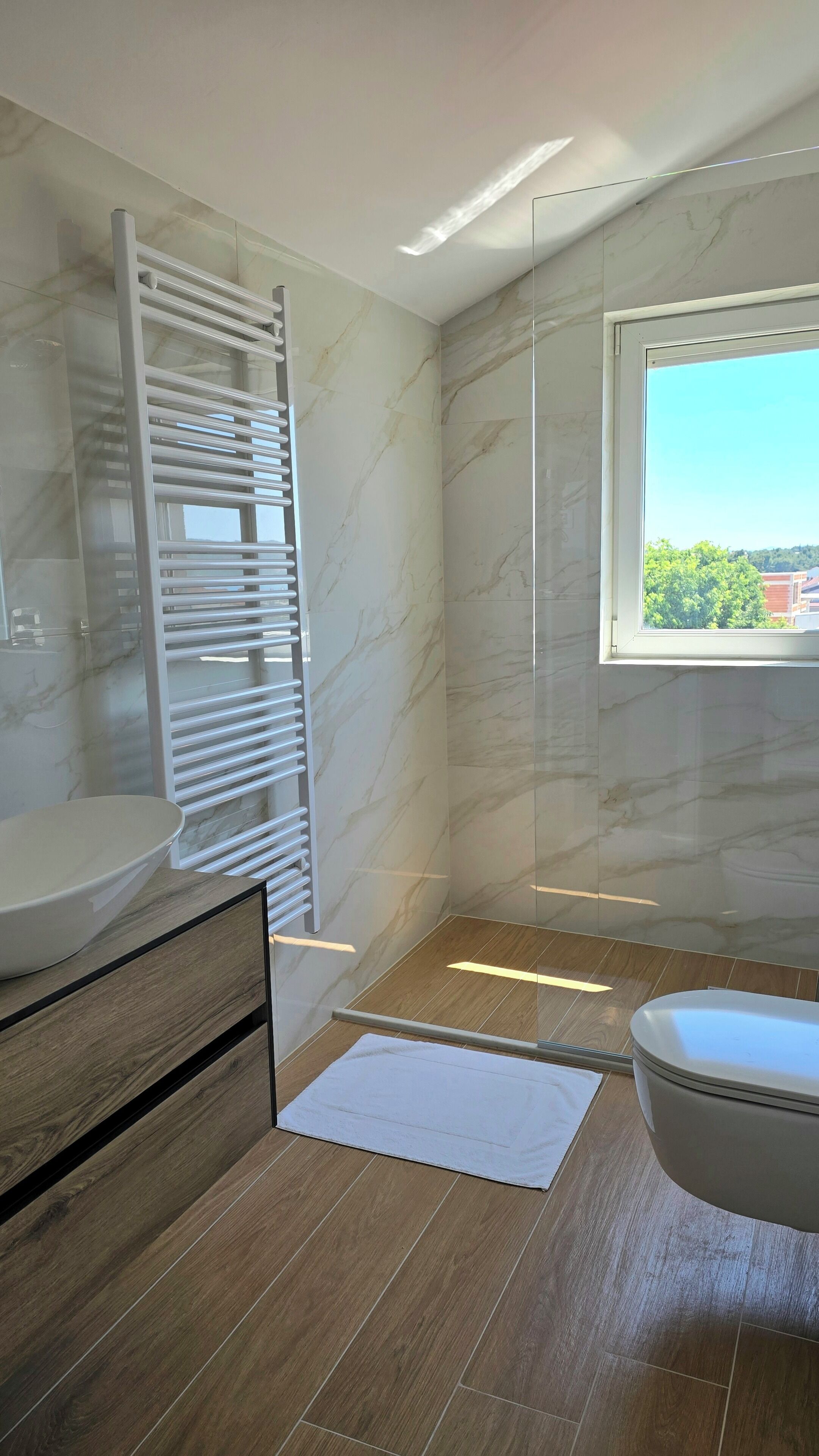 Une salle de bain moderne avec une douche à parois de verre, des toilettes et un lavabo.