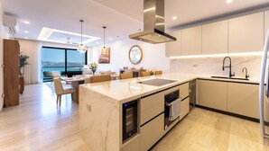 A modern kitchen with a built-in oven, a sink, and a dining area with a view. - Stunning 2nd-Level | Views of Ocean, Beach & Pool (Huatulco)