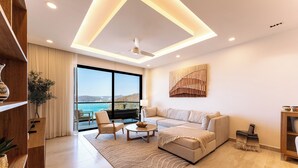 A modern living room with a sofa, armchairs, a coffee table, and a view of the sea. - Stunning 2nd-Level | Views of Ocean, Beach & Pool (Huatulco)
