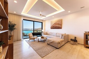 A modern living room with a sofa, armchairs, a coffee table, and a view of the sea. - Stunning 2nd-Level | Views of Ocean, Beach & Pool (Huatulco)