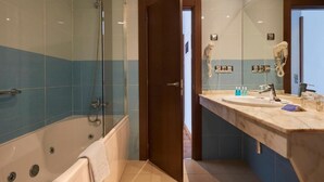 Un baño con bañera, ducha y tocador con espejo.
