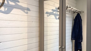 A bathroom with white paneled walls, a glass door, and a towel rack with a dark towel. - 4 Person Holiday Home in Tvaaker (Tvaaker)