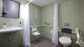 A bathroom with a shower, toilet, sink, and a mirror.