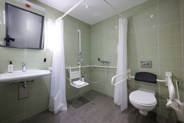 A bathroom with a shower, toilet, sink, and a mirror. - Premier Inn Freiburg City Nord (Freiburg im Breisgau)