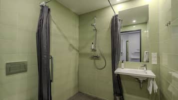 A bathroom with a shower, a sink, a mirror, and a towel rack.