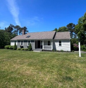 A single-story house with a front porch, a chimney, and a well-maintained lawn. - Short Drive to Red River Beach (Harwich)