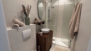 Un bagno moderno con servizi igienici, lavandino, doccia e specchio.