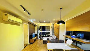Una sala de estar moderna con un sofá, una mesa de comedor y un televisor.